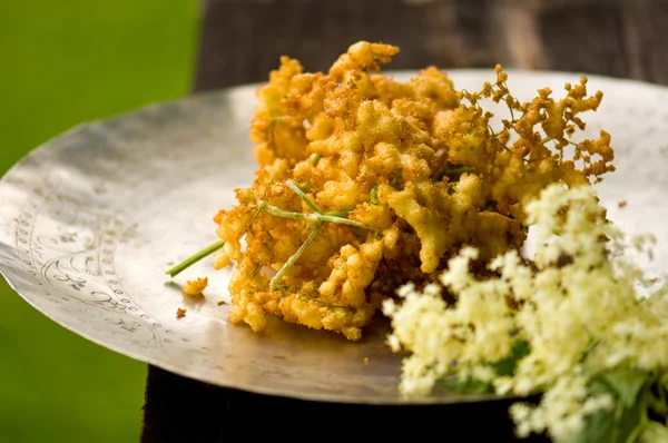 Flores de saúco al horno en el plato, primer plano —  Fotos de Stock