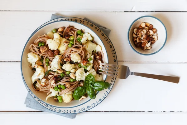 Whole-grain-spaghetti with roasted cauliflower, hazelnuts and ba — Stock Photo, Image