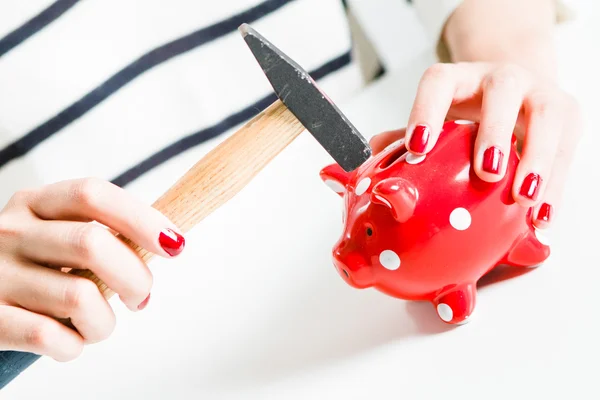 Piggy Bank vermelho e martelo realizada por mulher — Fotografia de Stock