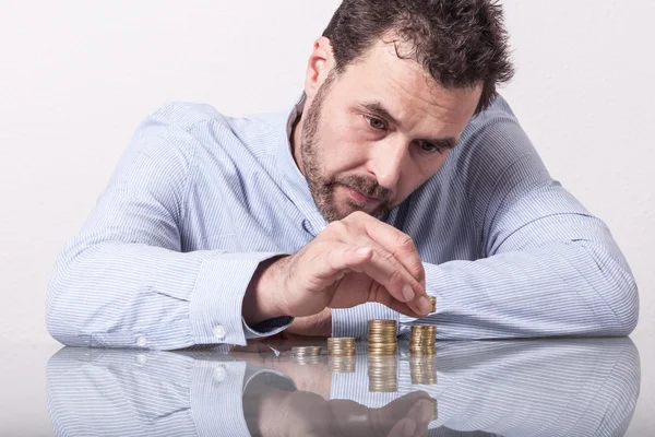 Ο άνθρωπος των επιχειρήσεων καταμέτρηση χρημάτων, στοίβες κερμάτων στο γραφείο — Φωτογραφία Αρχείου