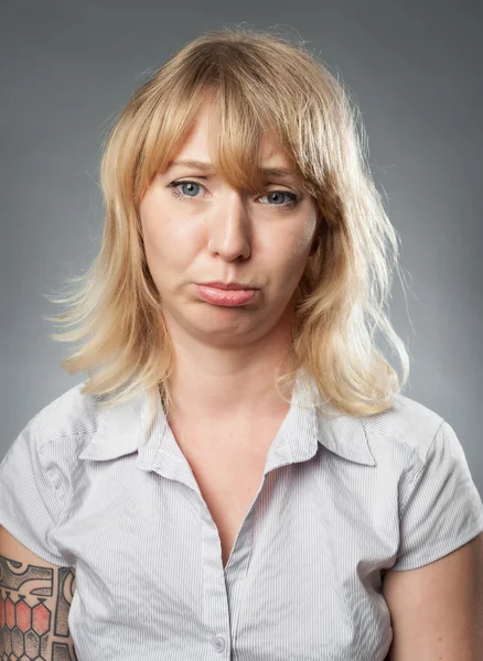 Ung kvinna porträtt på grå bakgrund, Skäggtorsk uttrycket — Stockfoto