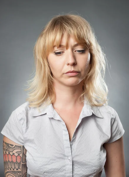 年轻女子肖像在灰色的背景下，悲伤的表情 — 图库照片