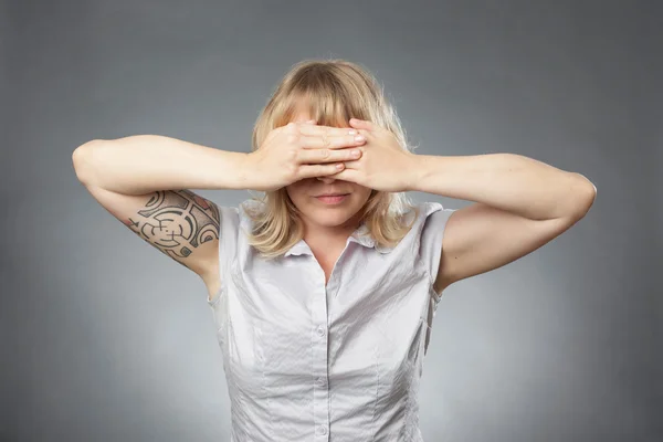 Portraits de jeune femme sur fond gris, couvrant ses yeux — Photo