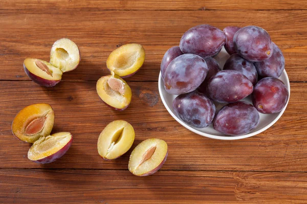 Plums on wood, halfed — Stock Photo, Image