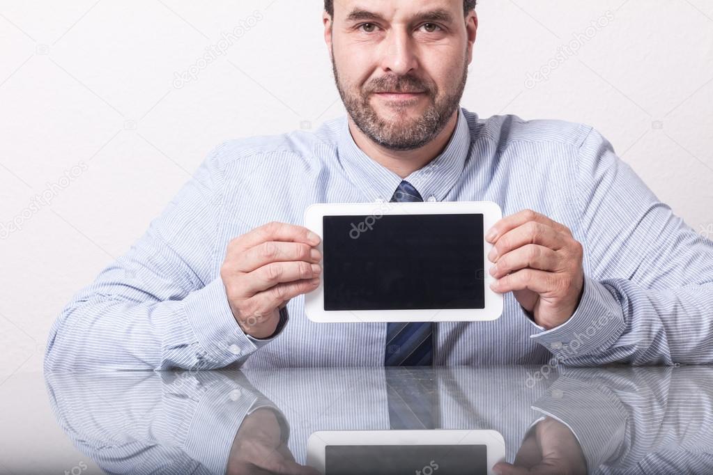 Business man on office desk, showing tablet computer with empty 