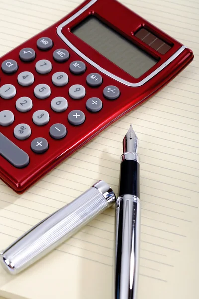 Penna e calcolatrice tascabile sdraiato su un foglio — Foto Stock