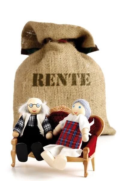 Two puppets sitting on sofa in front of sack — Stock Photo, Image