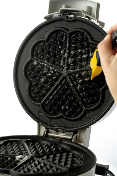 Greasing waffle iron with brush, close-up — Stock Photo, Image