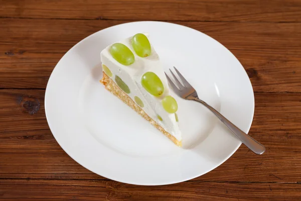 Pedaço de torta de uva com uvas verdes no prato — Fotografia de Stock
