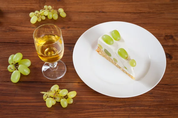 Pedaço de torta de uva com uvas verdes no prato, vinho branco — Fotografia de Stock
