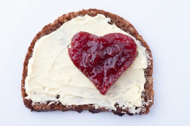 Tam tahıllı ekmek tereyağı ve kalp ile Ahududu reçeli şeklinde