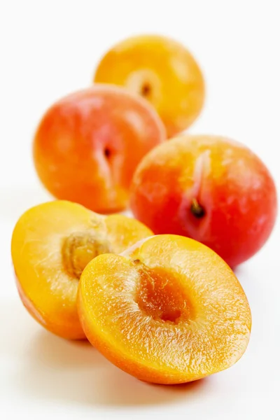 Halves and whole yellow plums — Stock Photo, Image
