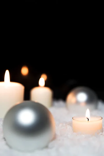 Baubles e velas brancas na neve artificial — Fotografia de Stock