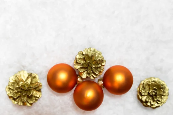 Palle arancioni e coni di abete dorato in neve artificiale, copia spa — Foto Stock