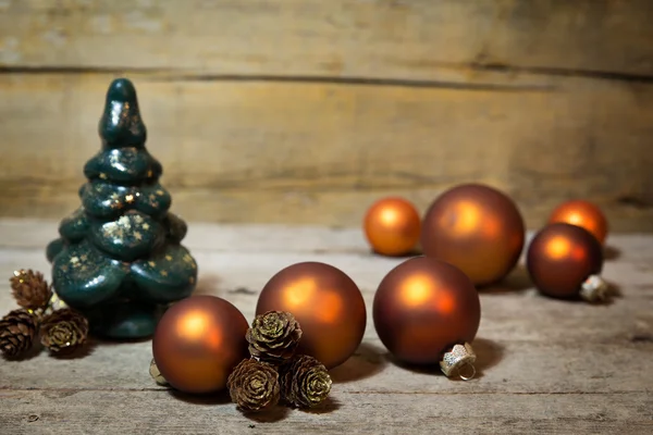 Orangenkugeln, Tannenzapfen und Weihnachtsbaum auf Holz — Stockfoto