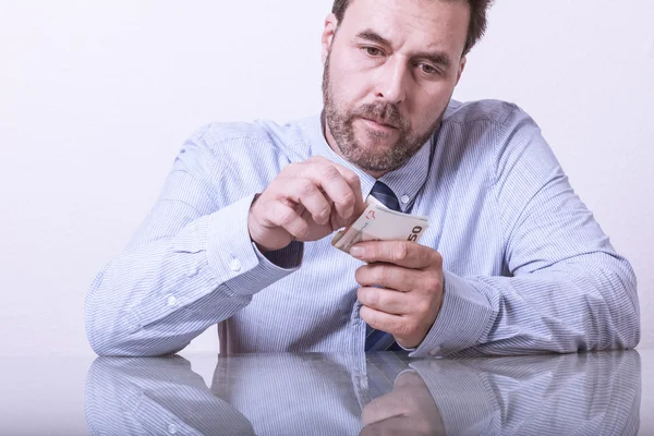 Mature man counting euro notes at glass desk — Stock Photo, Image