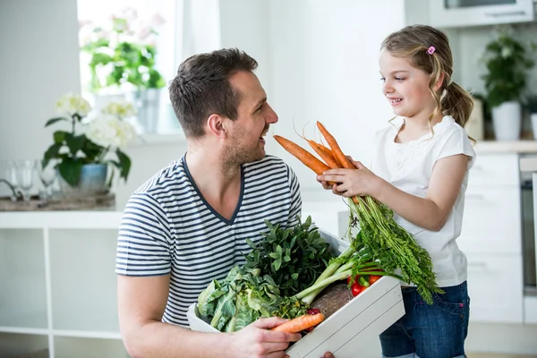 Father and daughter with vegetable box in kitchen — Stock Photo, Image