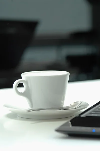 Close up de xícara de café com laptop na mesa — Fotografia de Stock