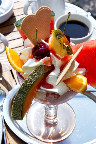 Sundae com várias frutas e xícara de café na mesa fora — Fotografia de Stock