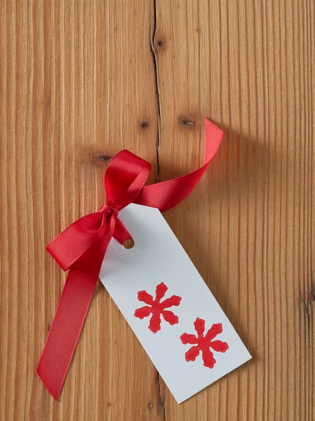Navidad, etiqueta de regalo, impreso, cinta roja, madera de fondo —  Fotos de Stock
