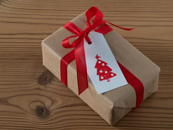 Karácsonyi ajándék ajándék címkére nyomtatott, piros szalag — Stock Fotó