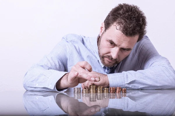 Business man counting money, stacks of coins on office desk Royalty Free Stock Images