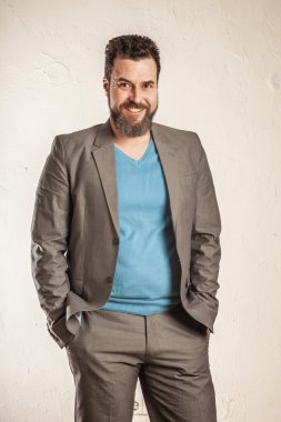 İş adamı sakallı, kendine güvenen gülümse, ceplerinde eller.