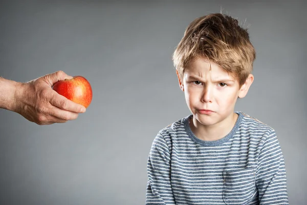 Портрет мальчика, рука с яблоком, отказался, серый фон — стоковое фото