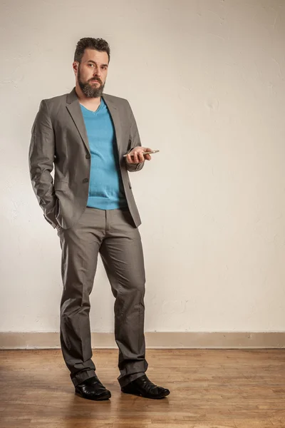 Зрілий бізнесмен з бородою тримає смартфон — стокове фото