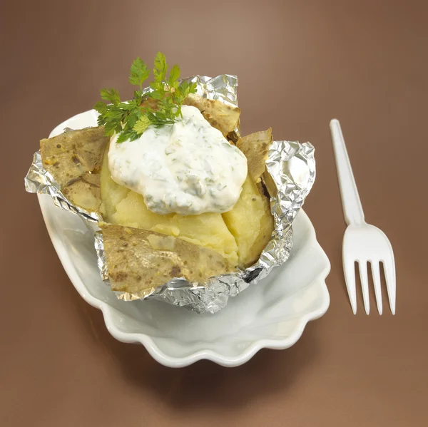 Baked potato with curd cheese in foil — Stock Photo, Image