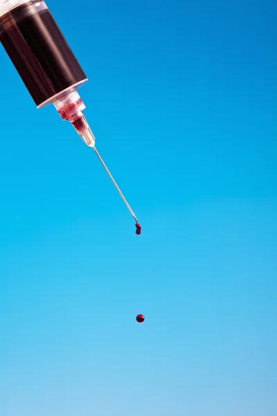 Syringe filled with blood sample drop — Stock Photo, Image