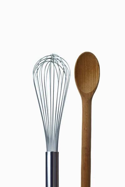 Wooden spoon and eggbeater — Stock Photo, Image
