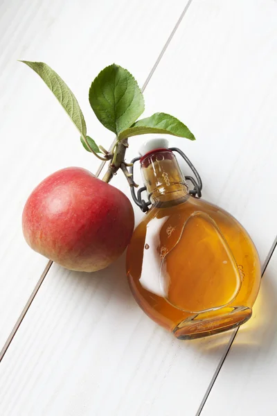 Apple and glas bottle with apple cider — Stock Photo, Image