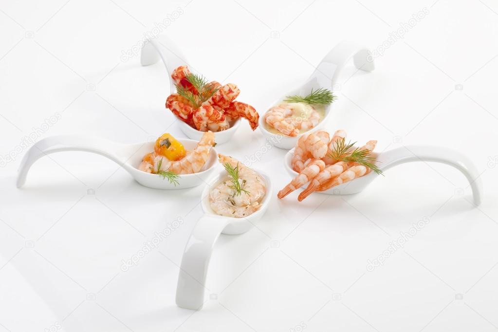 Shrimps with vegetables on spoons