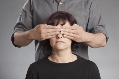 Man standing behind woman covering her eyes clipart