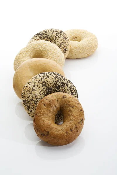 Bagels com sementes de papoila bagels com gergelim bagels integrais no fundo branco — Fotografia de Stock