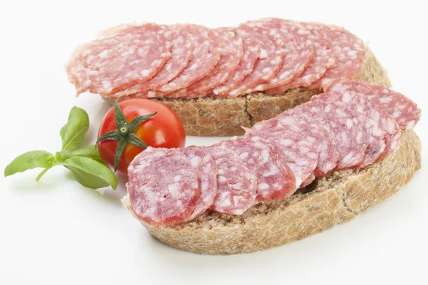 Salami segmenten op sneetjes brood — Stockfoto