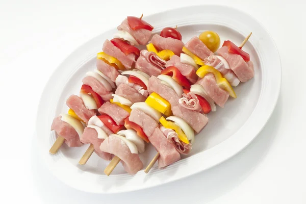 Raw shashlik skewers on plate, elevated view — Stock Photo, Image