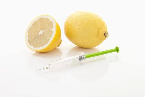 Citron et seringue sur fond blanc, gros plan — Photo