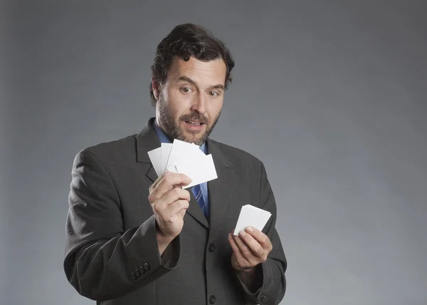 Geschäftsmann mit Visitenkarte vor grauem Hintergrund — Stockfoto