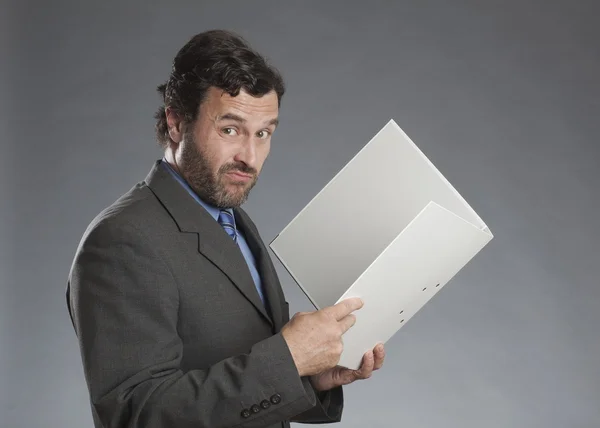 Бизнесмен держит папку на сером фоне — стоковое фото