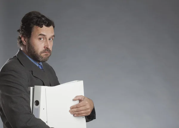 Businessman holding folder against gray background — Stock Photo, Image