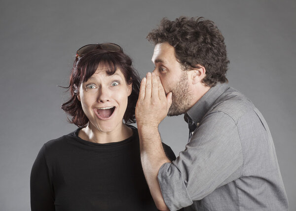 Зрелая пара мужчина шепчет тайну в ухо женщине
