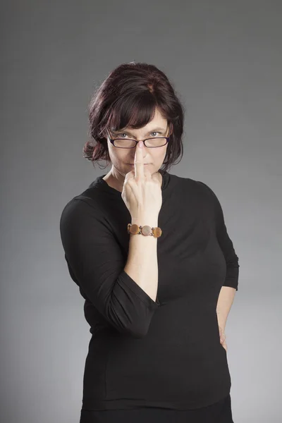 Mujer morena madura con gafas sobre fondo gris —  Fotos de Stock