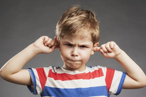 Jongen die betrekking hebben op oren tegen de grijze achtergrond — Stockfoto