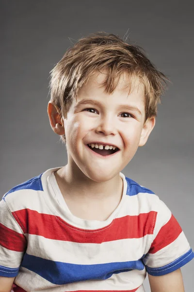 灰色の背景に対して笑っている若い男の子の肖像画 — ストック写真