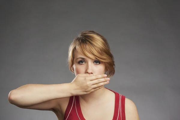 Adolescente chica en rojo tanque superior cubriendo los ojos contra el fondo gris — Foto de Stock