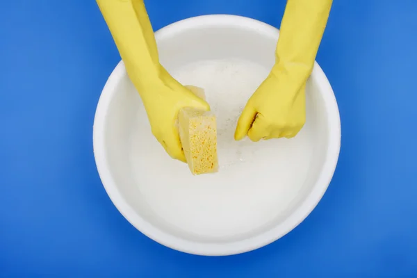 Hands wearing rubber gloves, plastic basin, sponge — Stock Photo, Image