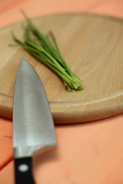 Erba cipollina e coltello sul tagliere — Foto Stock