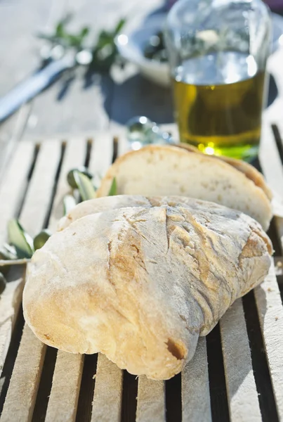 Italy, Tuscany, Magliano, Close up of bread and olive oil on wooden table — Stockfoto